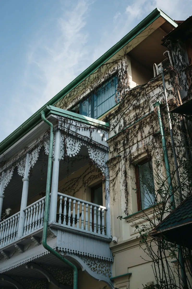 A carved balcony with weathered green timber in Tbilisi